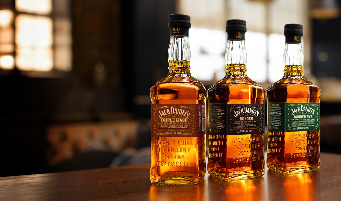 3 bonded series bottles on a table backlit by a window