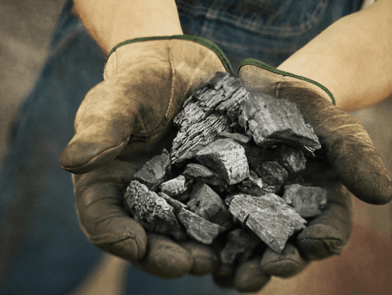 charcoal in gloved hands