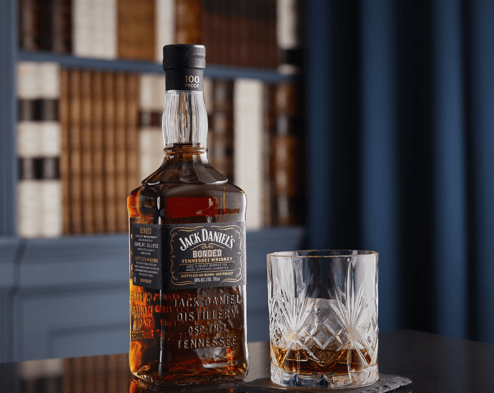 Picture of a jack daniel's bonded bottle next to a tasting glass
