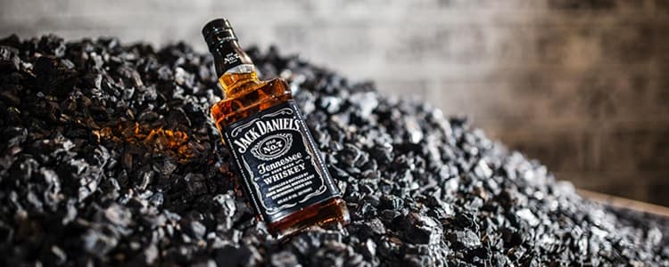 Jack Daniel's Bottle on heap of charcoal
