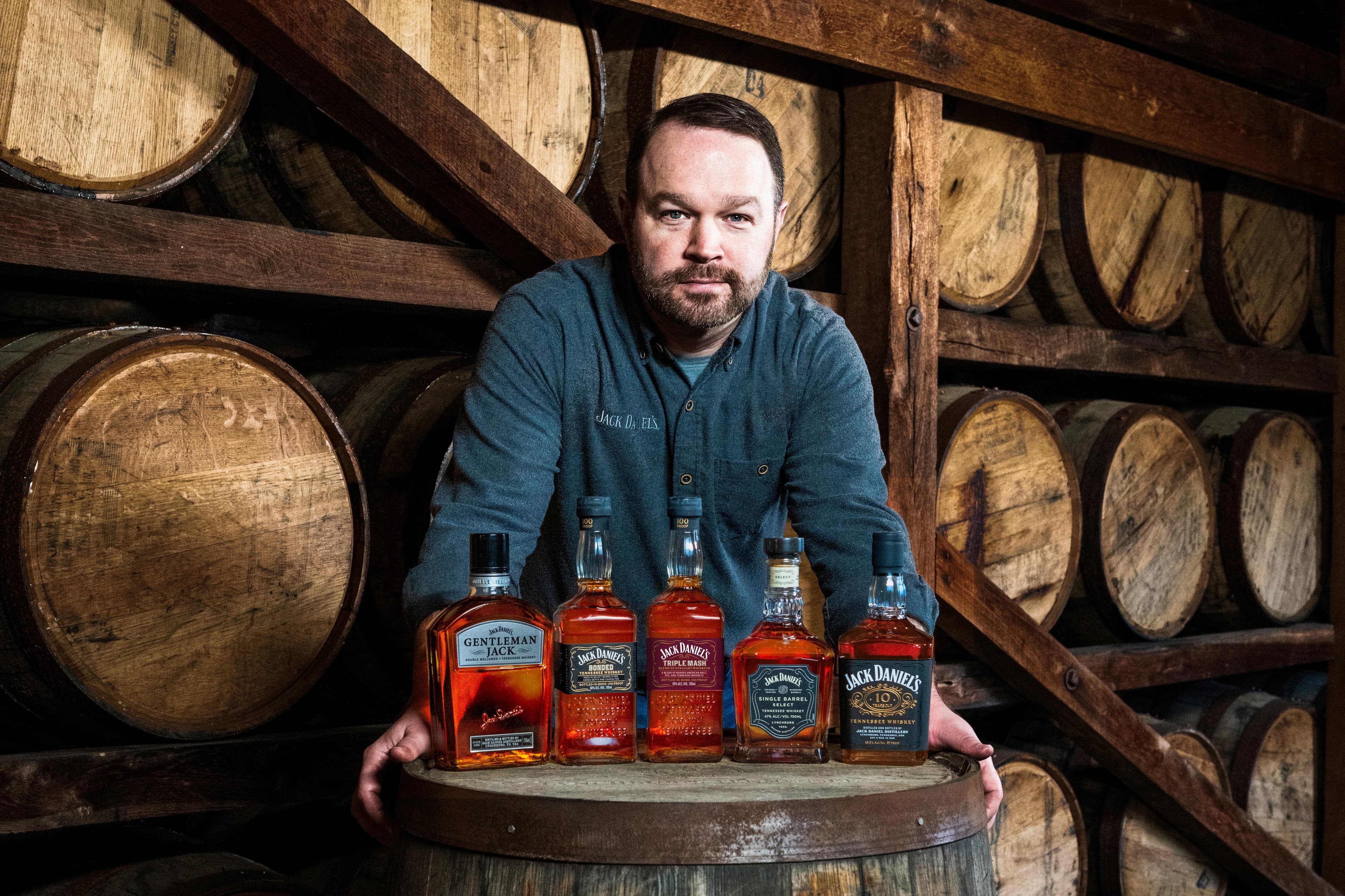 Jack Daniel's Master Distiller Chris Fletcher in front of a variety of Jack Daniel's whiskeys.