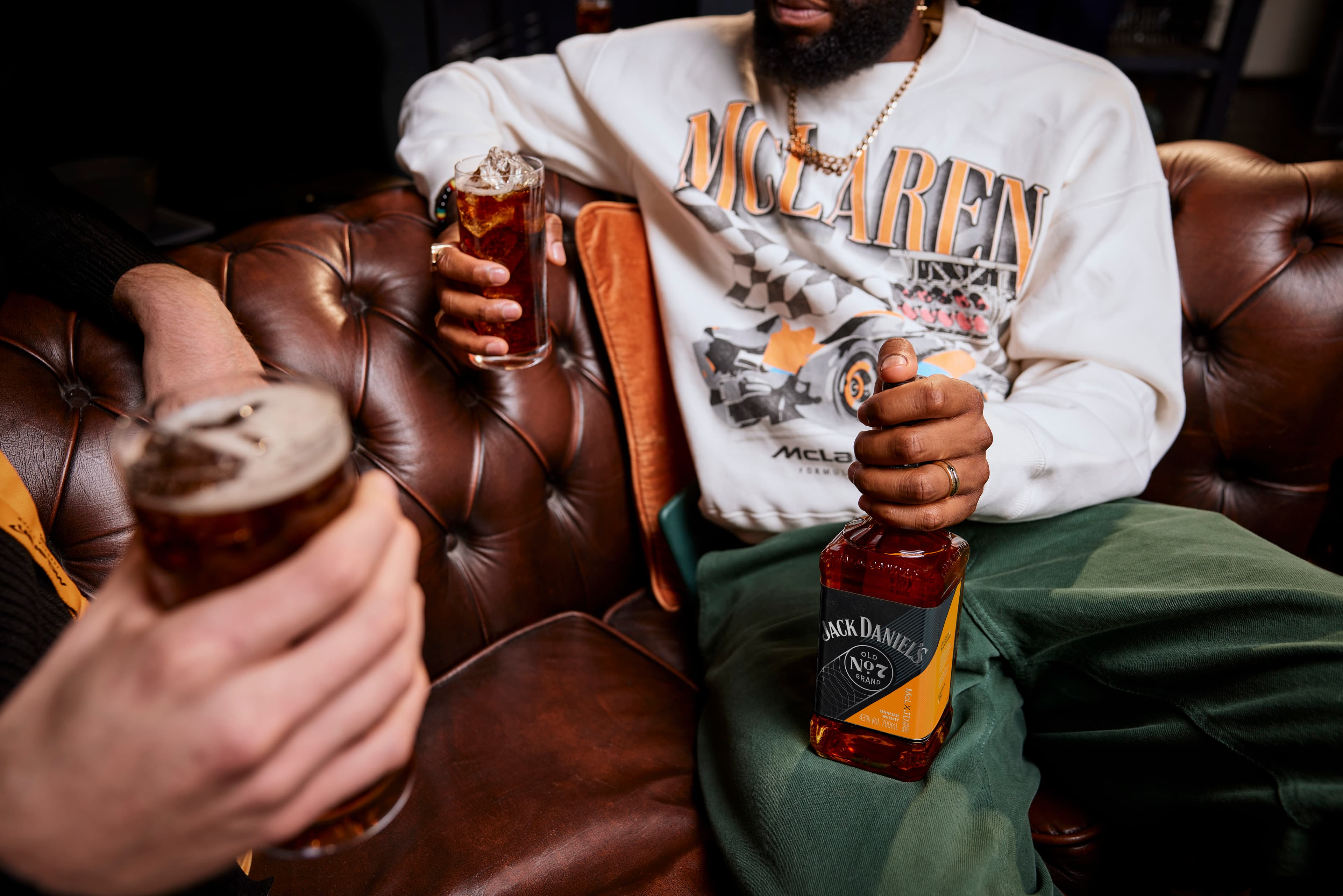 Man in McLaren shirt holding a bottle of the 2025 Jack Daniel's x McLaren Limited Release bottle
